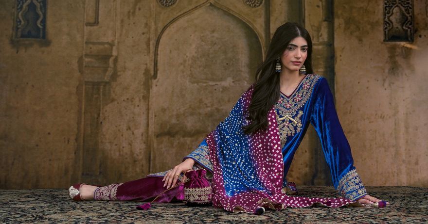 Amara & Sara ad creative with a model seated in a blue bandhani outfit